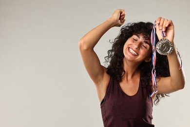 Photo of Happy winner with different medals on light grey background. Space for text