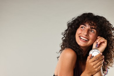 Photo of Happy winner with different medals on light grey background. Space for text