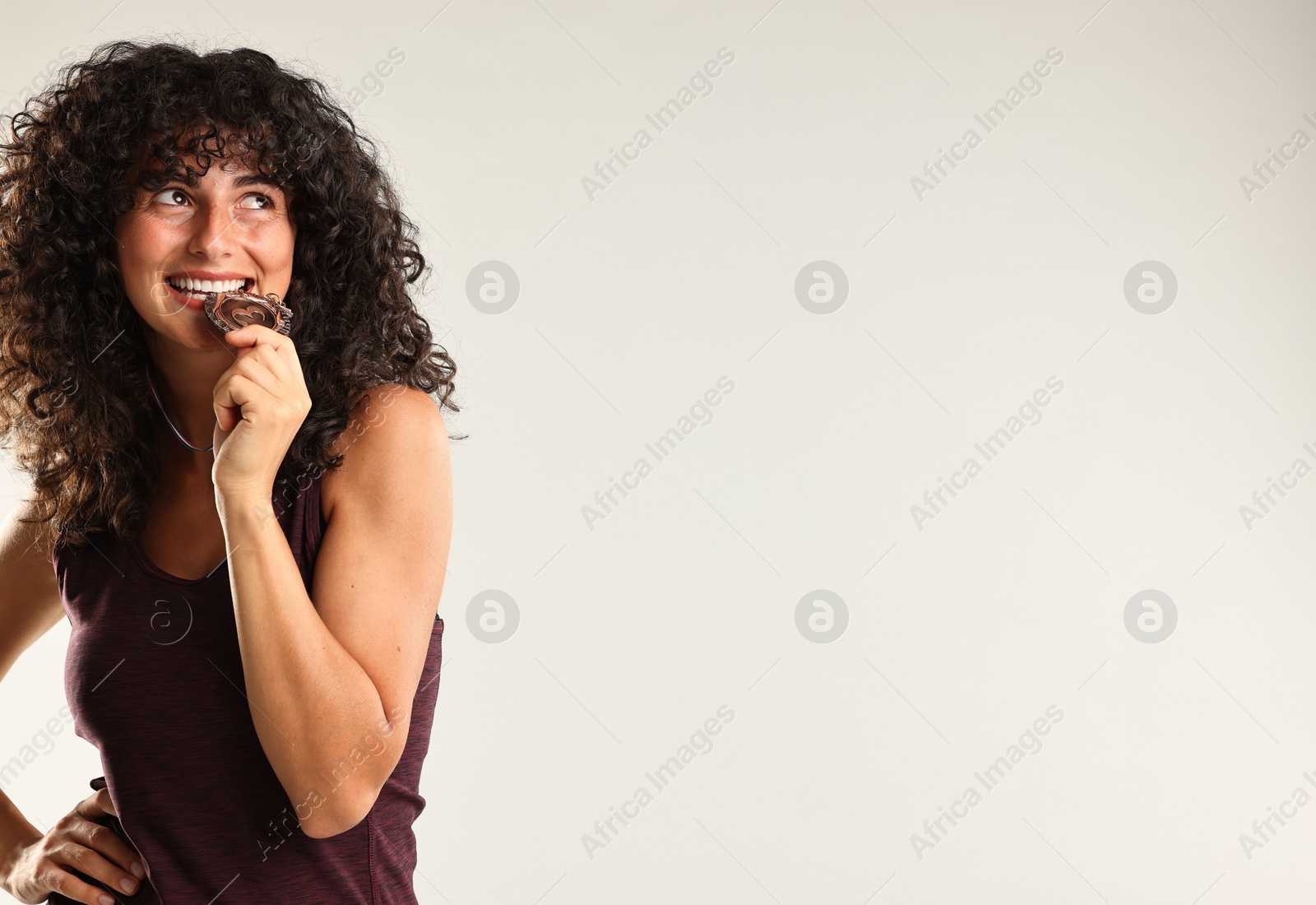 Photo of Happy winner with bronze medal on light grey background. Space for text