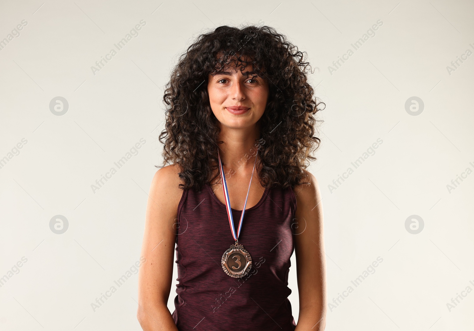 Photo of Portrait of winner with bronze medal on light grey background