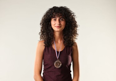 Photo of Portrait of winner with bronze medal on light grey background