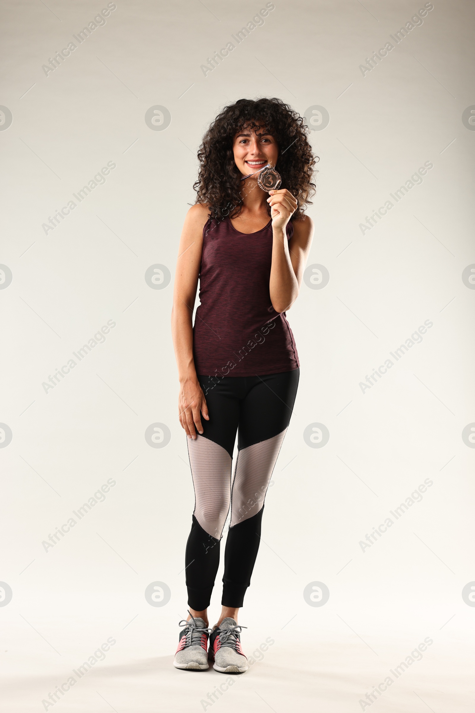 Photo of Happy winner with bronze medal on light grey background