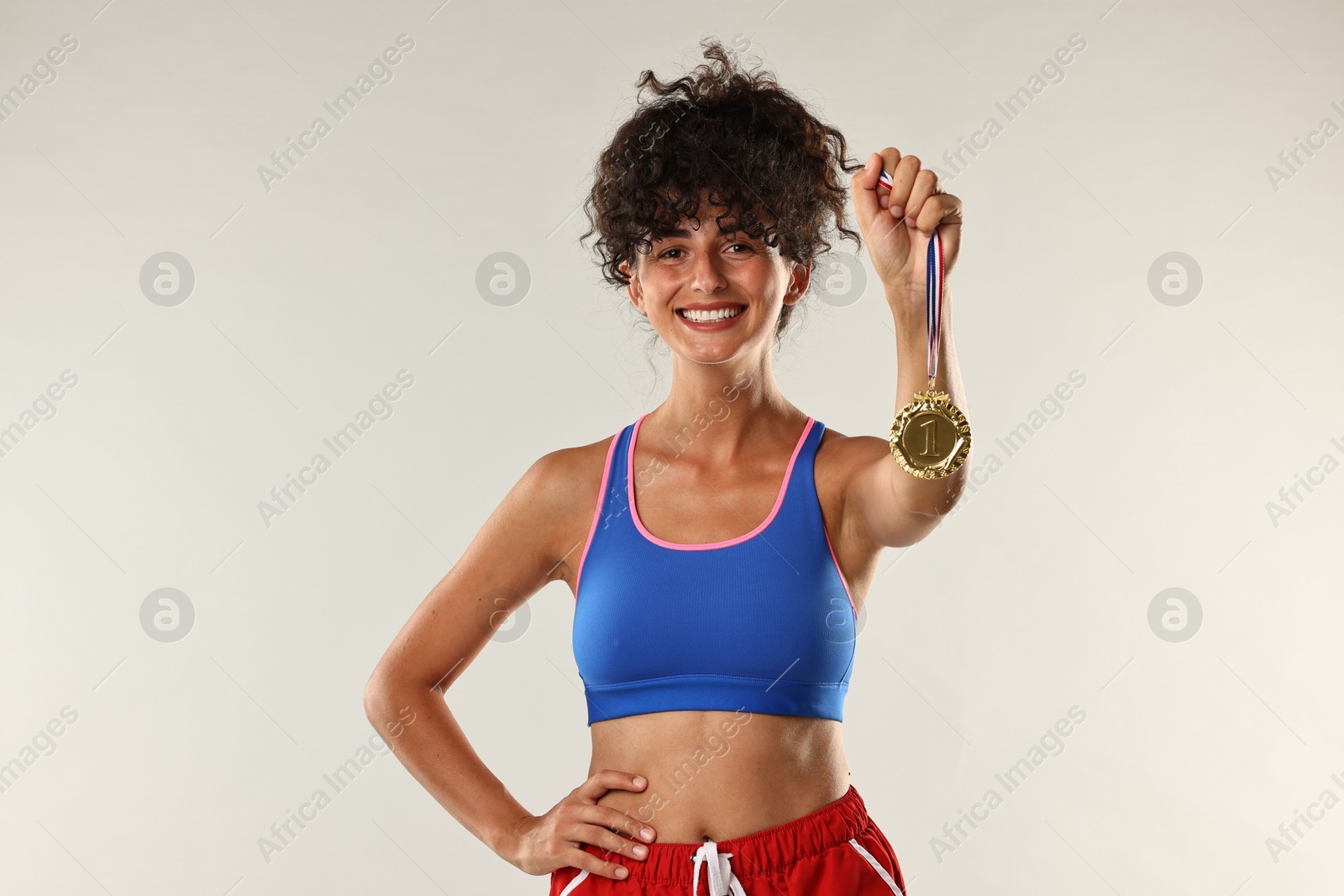 Photo of Happy winner with golden medal on light background