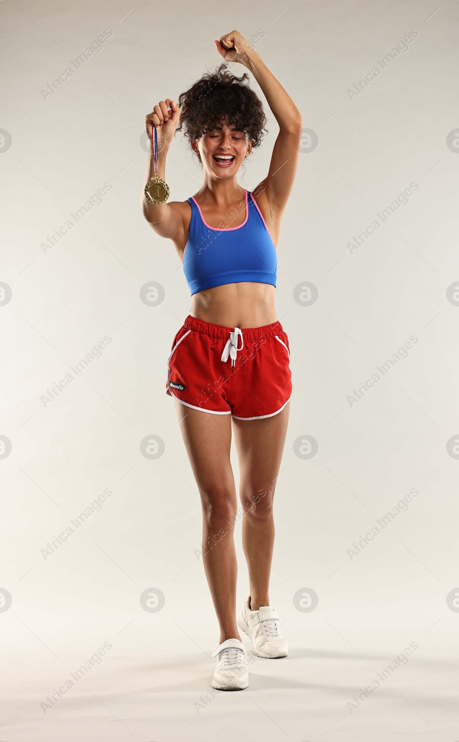 Photo of Happy winner with golden medal on light background