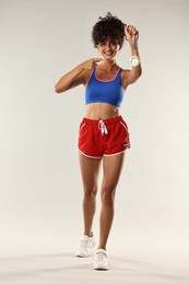 Photo of Happy winner pointing at golden medal on light background