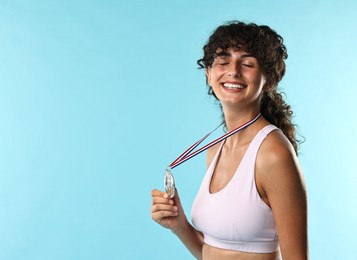 Photo of Happy winner with silver medal on light blue background. Space for text