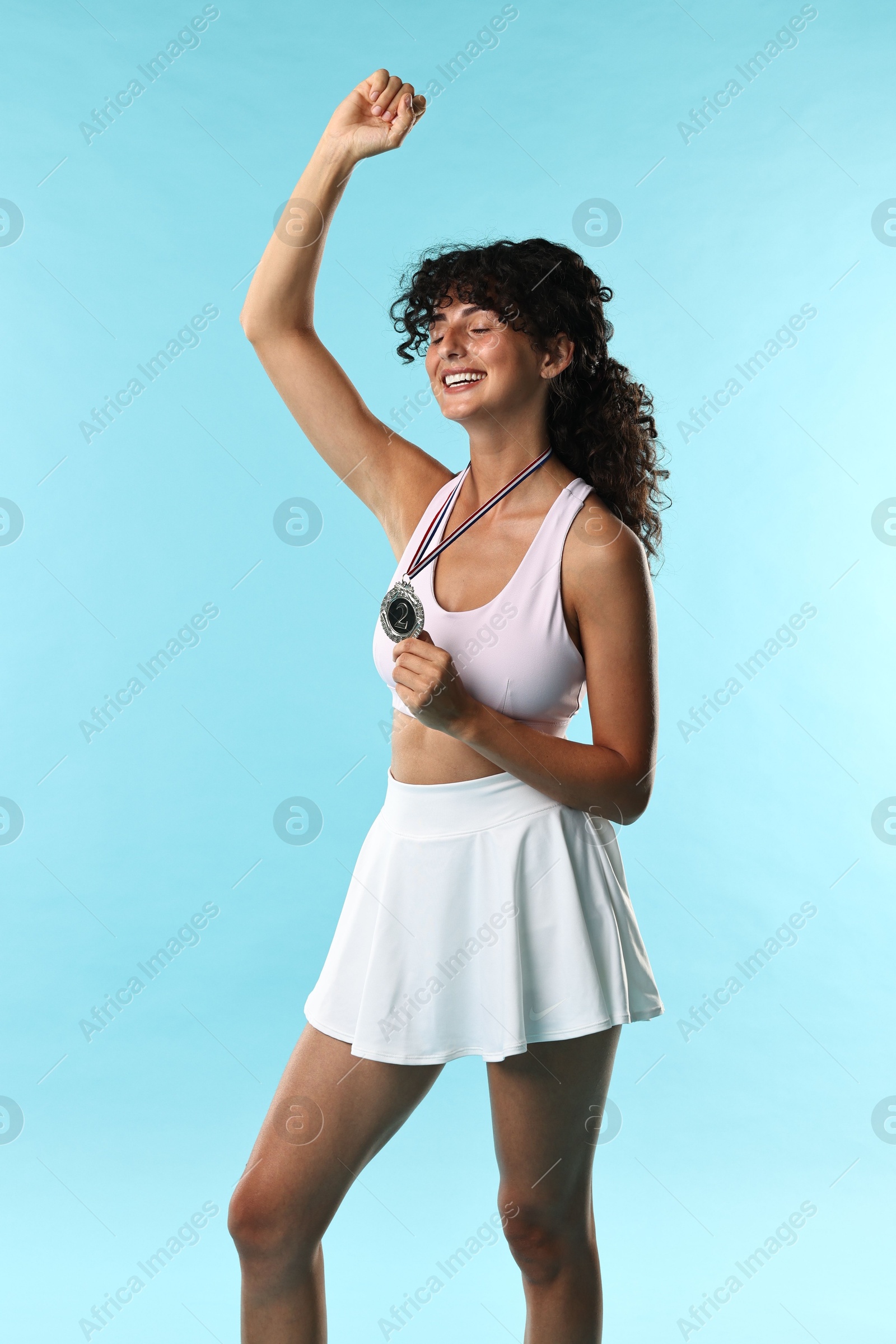 Photo of Happy winner with silver medal on light blue background