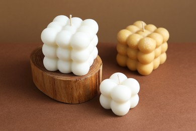 Photo of Beautiful bubble candles on brown table, closeup