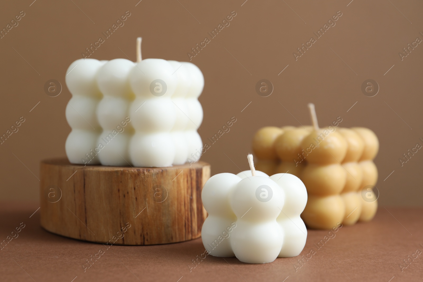 Photo of Beautiful bubble candles on brown table, closeup