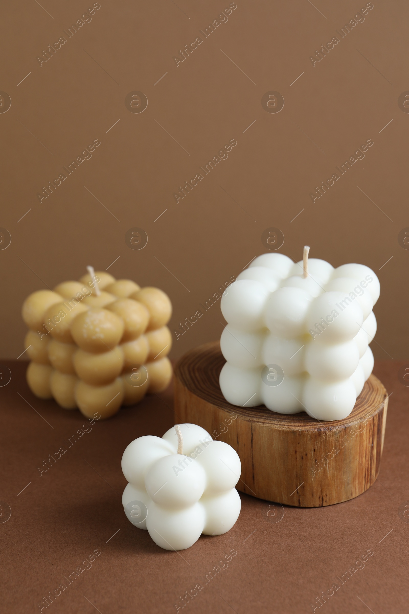 Photo of Three beautiful bubble candles on brown table