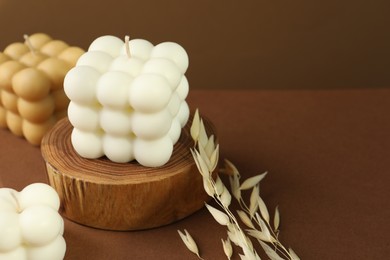 Photo of Beautiful bubble candles and spikes on brown table