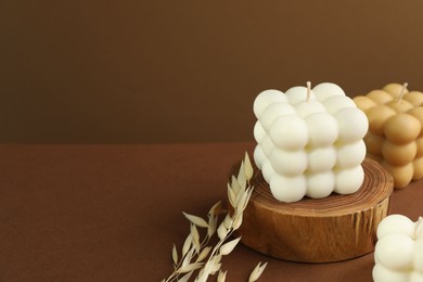 Photo of Beautiful bubble candles and spikes on brown table