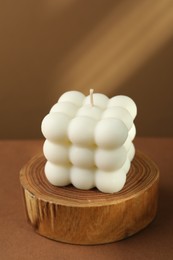 Photo of One beautiful bubble candle on brown table, closeup