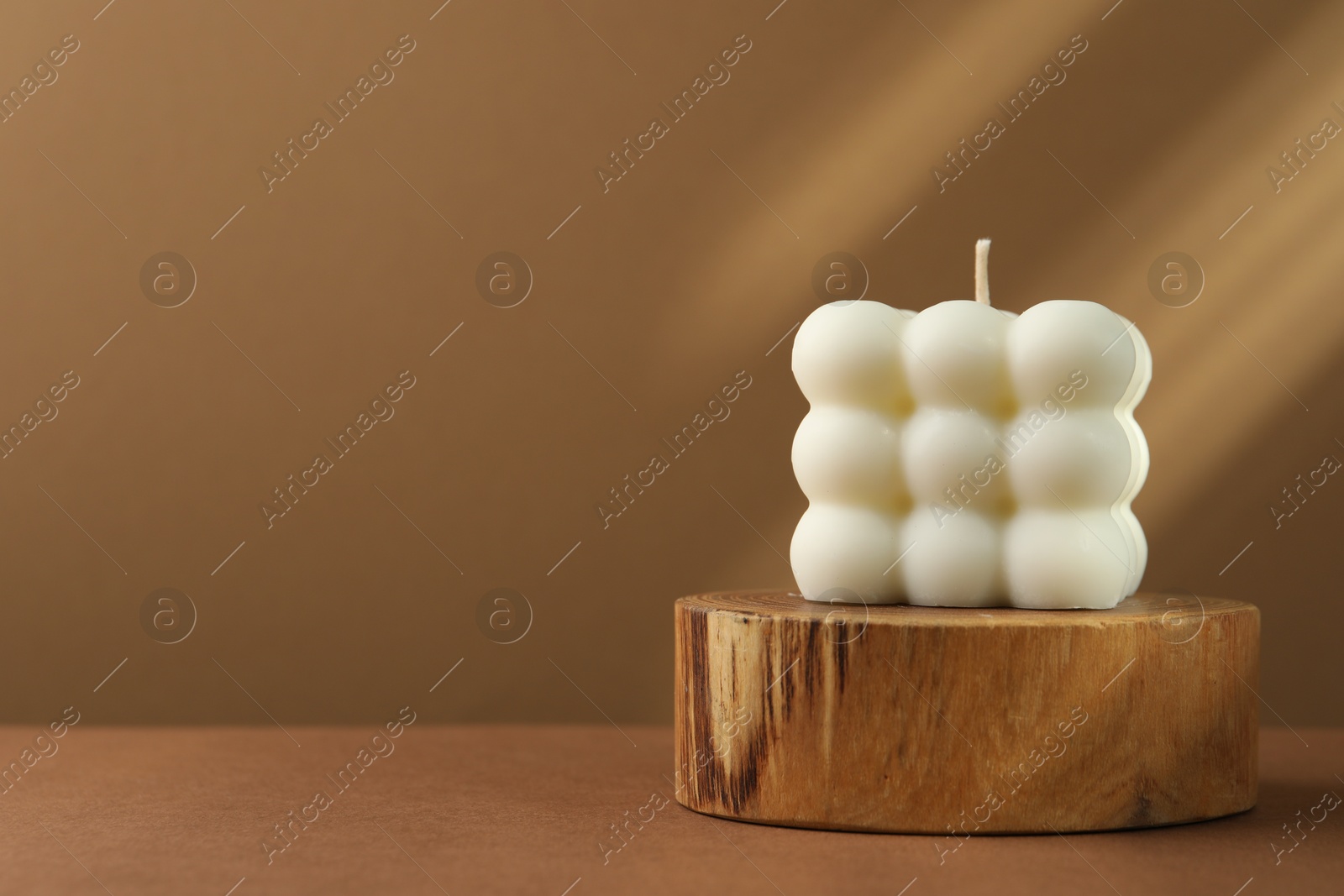 Photo of One beautiful bubble candle on brown table, space for text