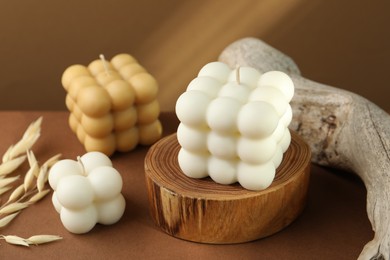 Photo of Beautiful bubble candles and spikes on brown table