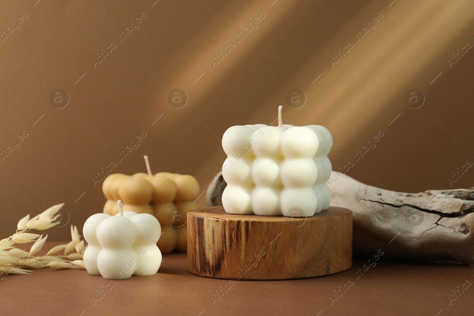 Photo of Beautiful bubble candles and spikes on brown table