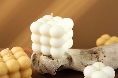 Photo of Beautiful bubble candles and snag on table, closeup