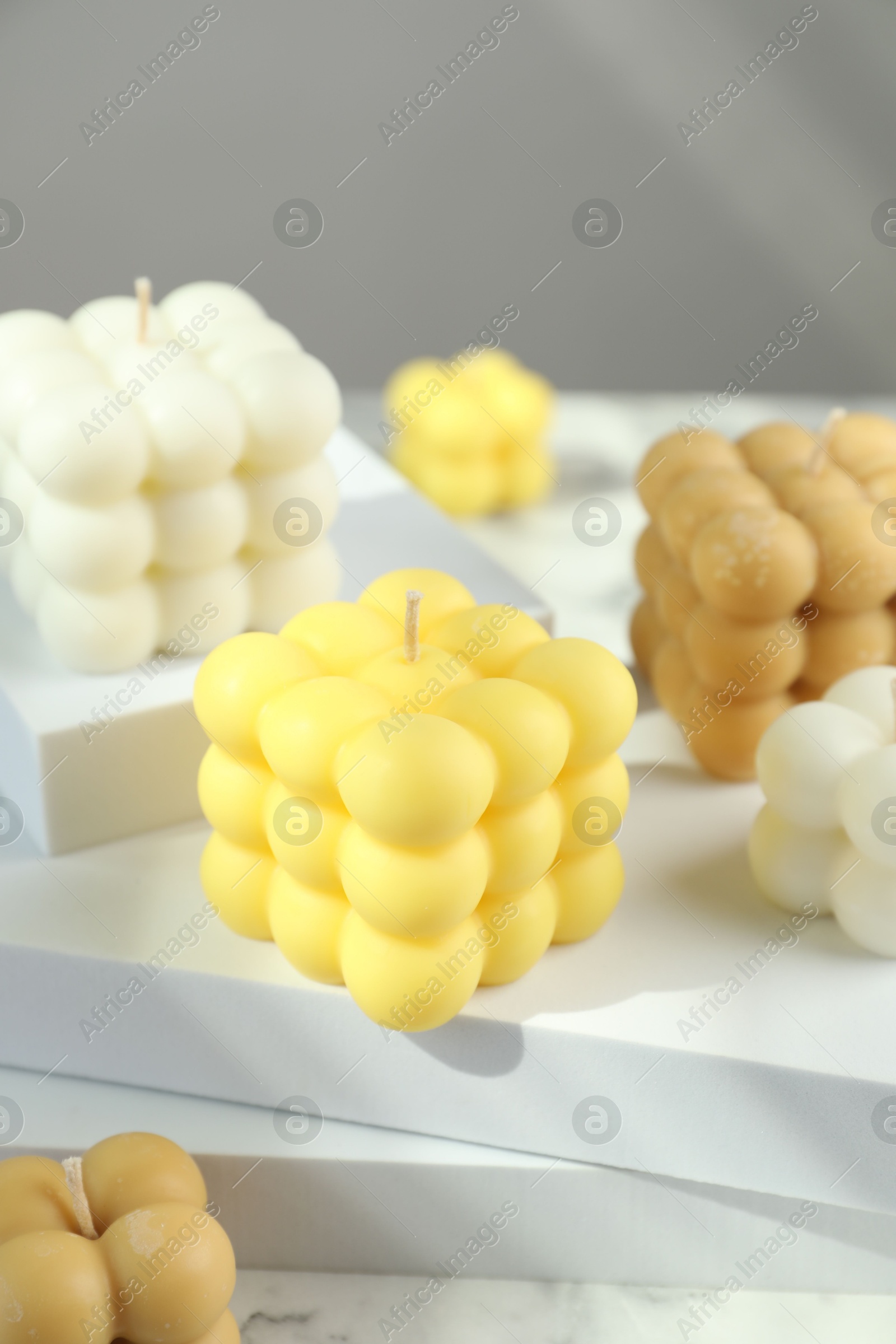 Photo of Beautiful bubble candles and geometric figures on table, closeup