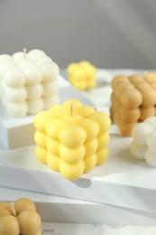 Photo of Beautiful bubble candles and geometric figures on table, closeup