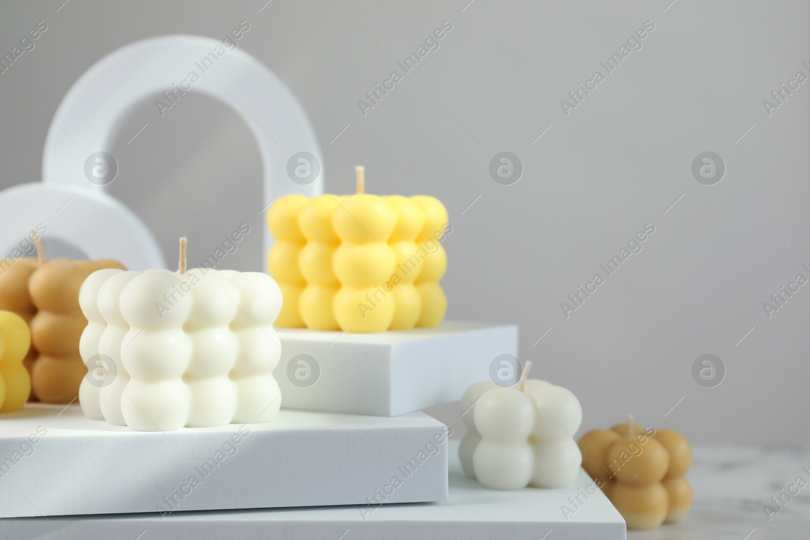 Photo of Beautiful bubble candles and geometric figures on table