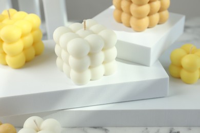 Photo of Beautiful bubble candles and geometric figures on table, closeup