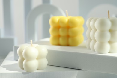 Photo of Beautiful bubble candles and geometric figures on table, closeup