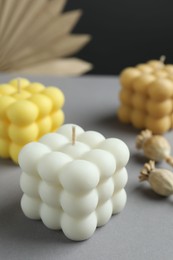 Photo of Beautiful bubble candles and decor on grey table, closeup