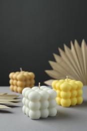 Photo of Beautiful bubble candles and decor on grey table