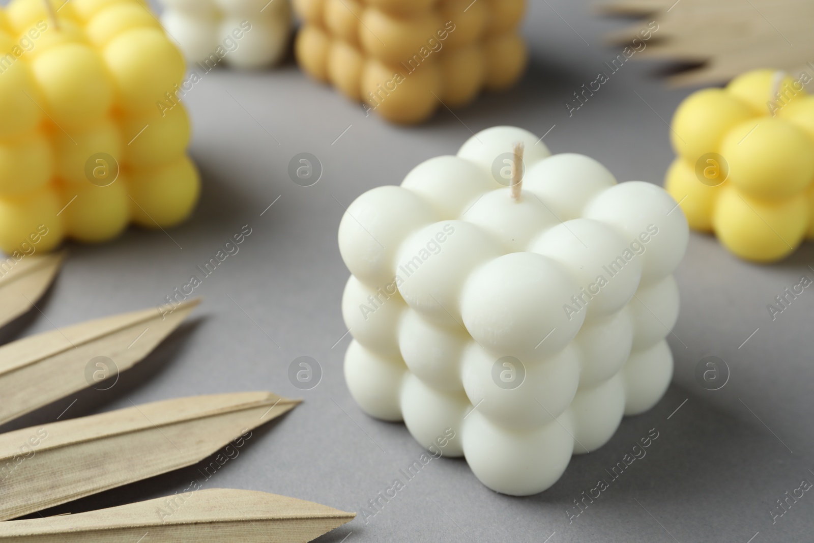 Photo of Beautiful bubble candles and decor on grey table, closeup