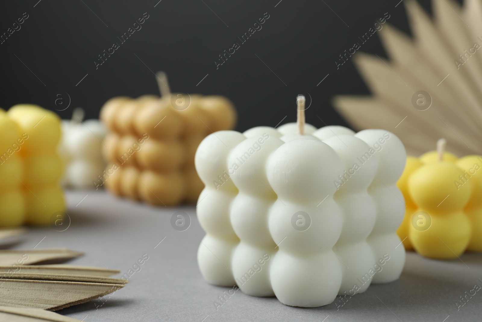 Photo of Beautiful bubble candles and decor on grey table, closeup