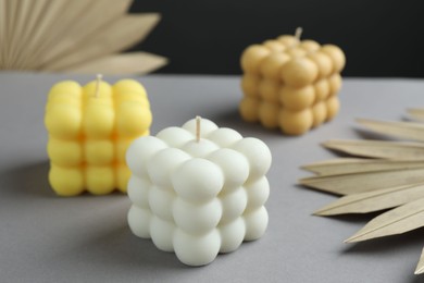 Photo of Beautiful bubble candles and decor on grey table, closeup