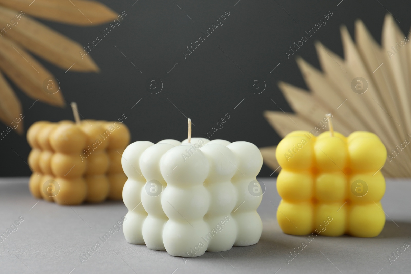 Photo of Beautiful bubble candles and decor on grey table, closeup