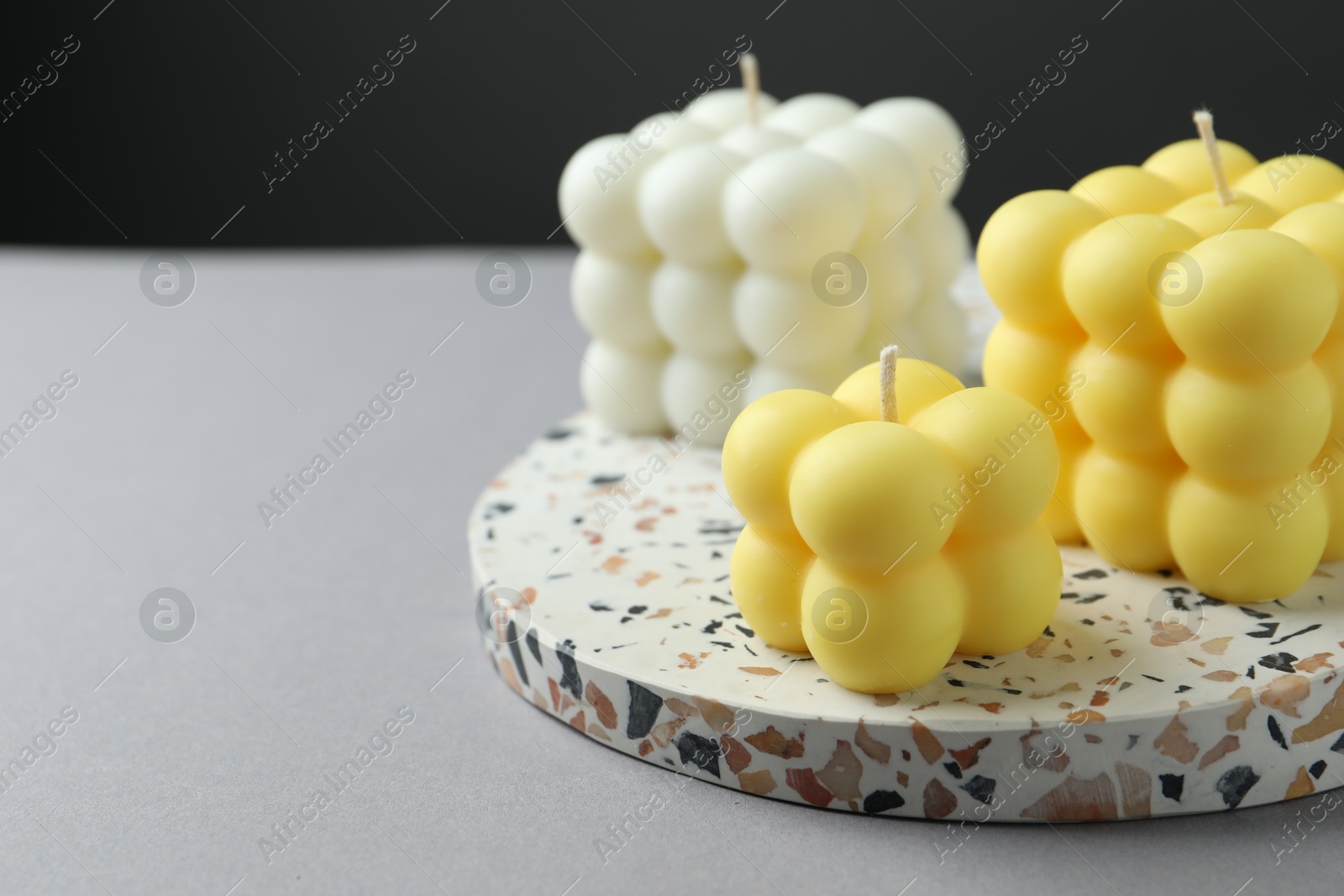 Photo of Beautiful bubble candles on grey table, closeup. Space for text