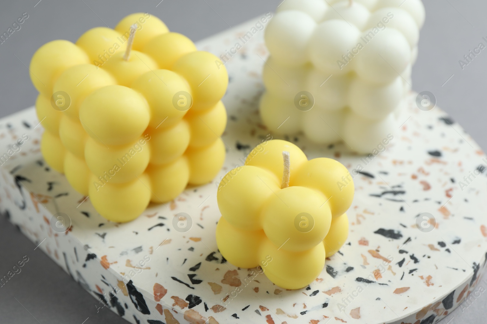 Photo of Beautiful colorful bubble candles on grey table, closeup