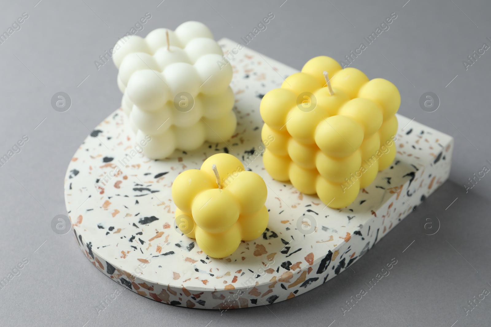 Photo of Beautiful colorful bubble candles on grey table, closeup