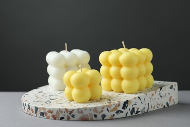 Photo of Beautiful colorful bubble candles on grey table