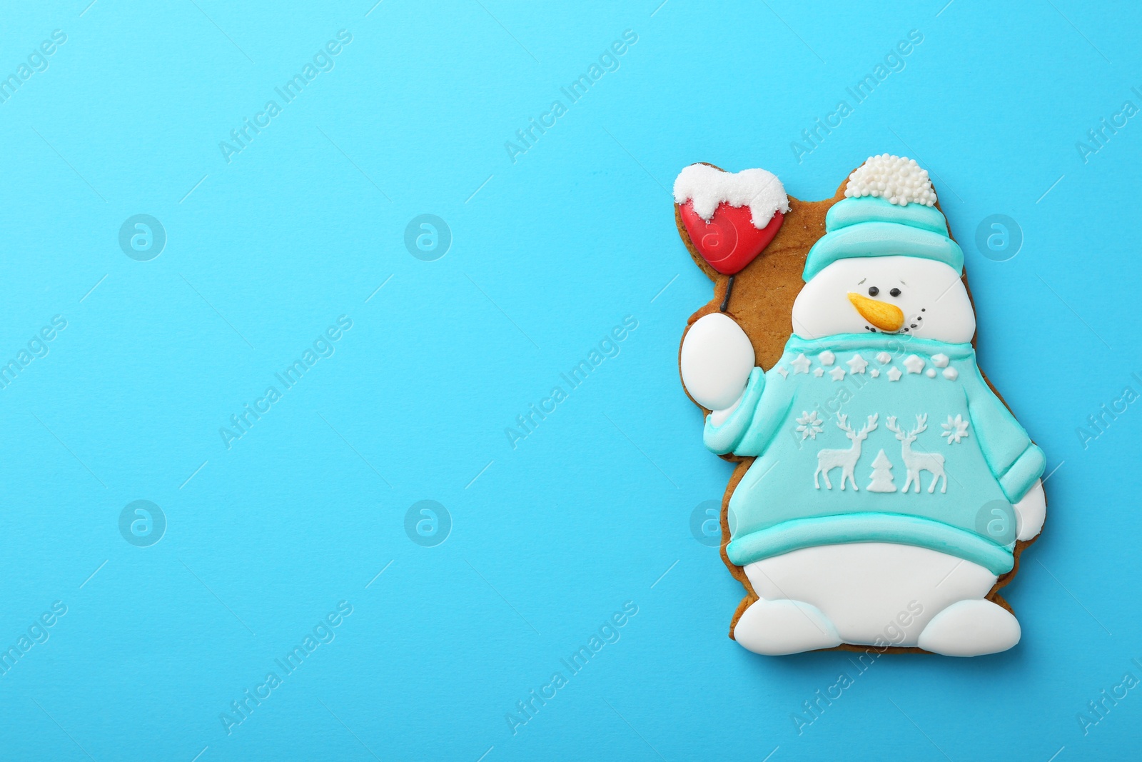 Photo of Tasty Christmas cookie in shape of snowman on light blue background, top view. Space for text