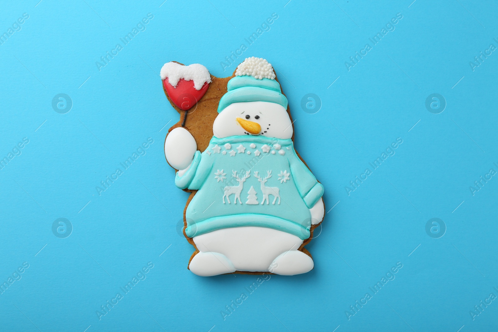 Photo of Tasty Christmas cookie in shape of snowman on light blue background, top view