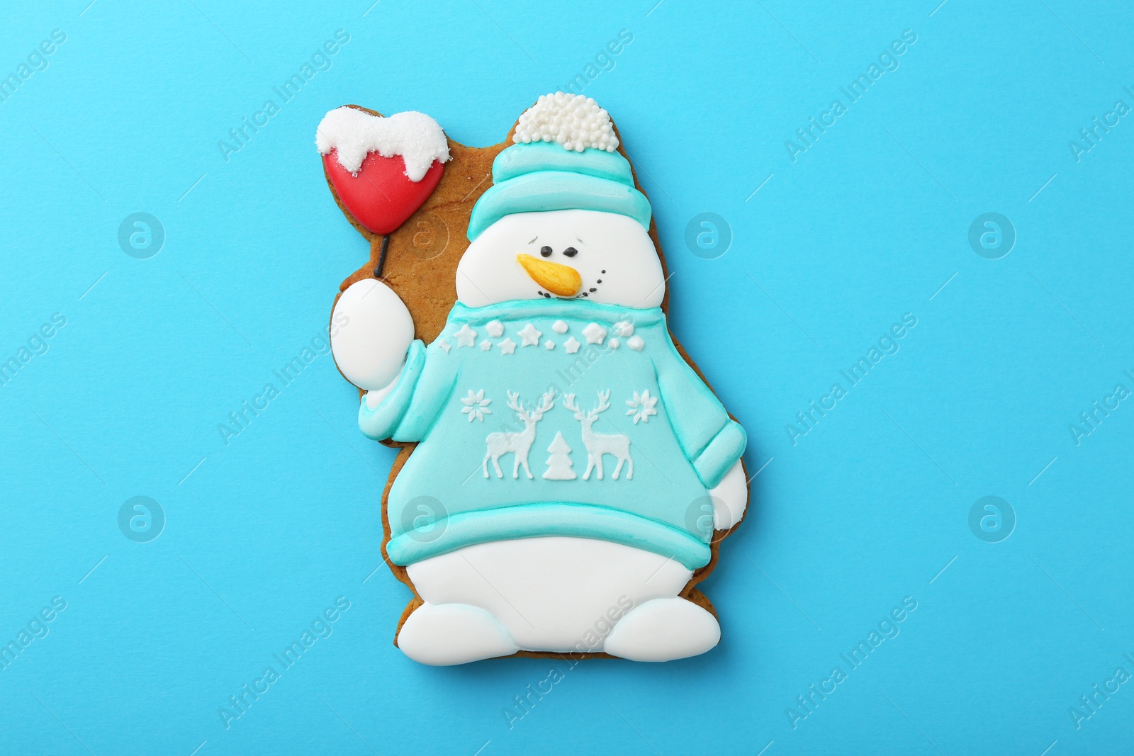 Photo of Tasty Christmas cookie in shape of snowman on light blue background, top view