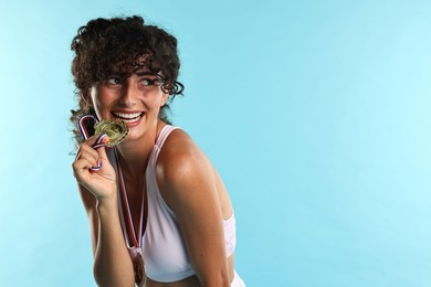 Photo of Happy winner with different medals on light blue background. Space for text