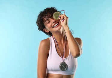 Happy winner with different medals on light blue background