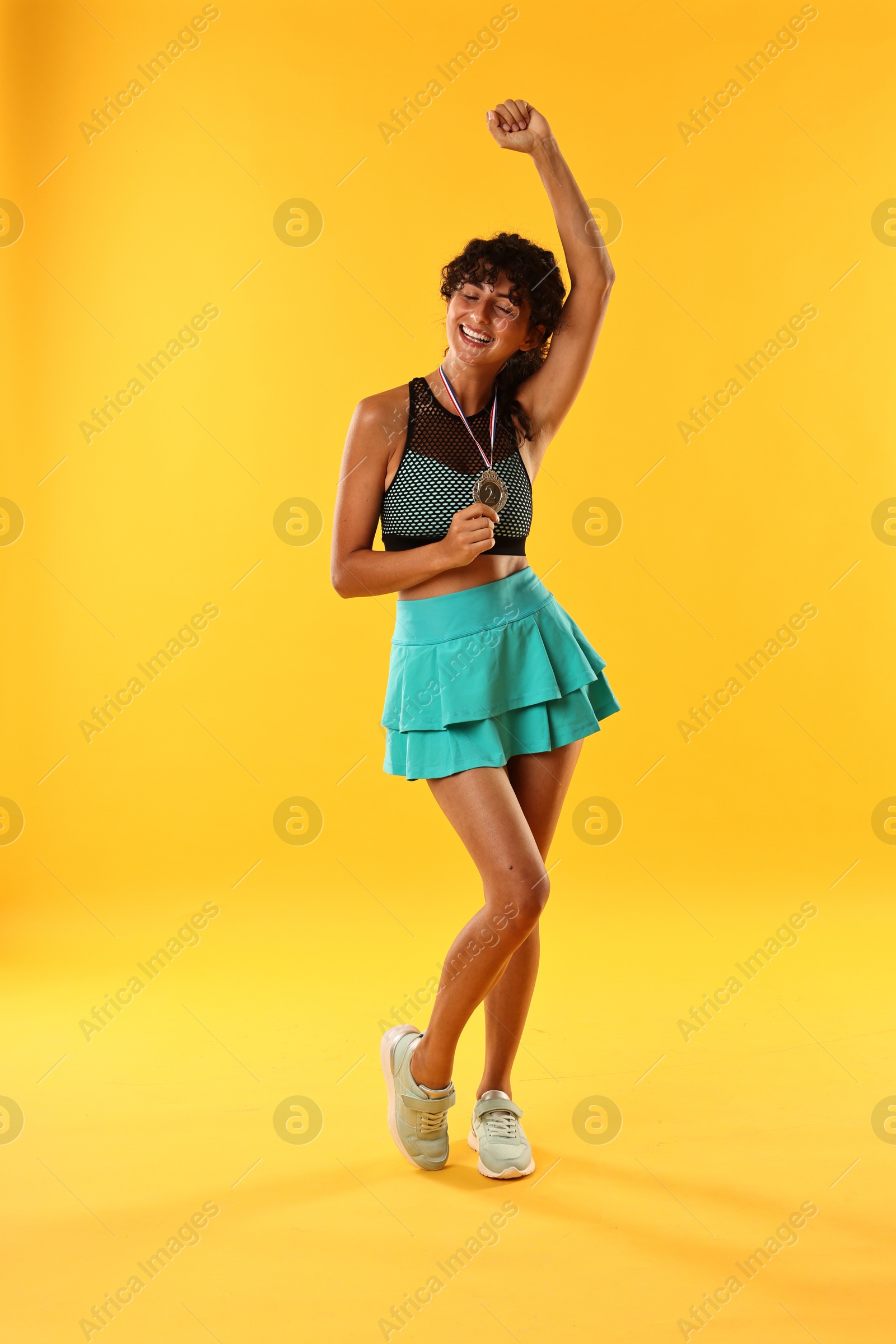 Photo of Happy winner with silver medal on yellow background