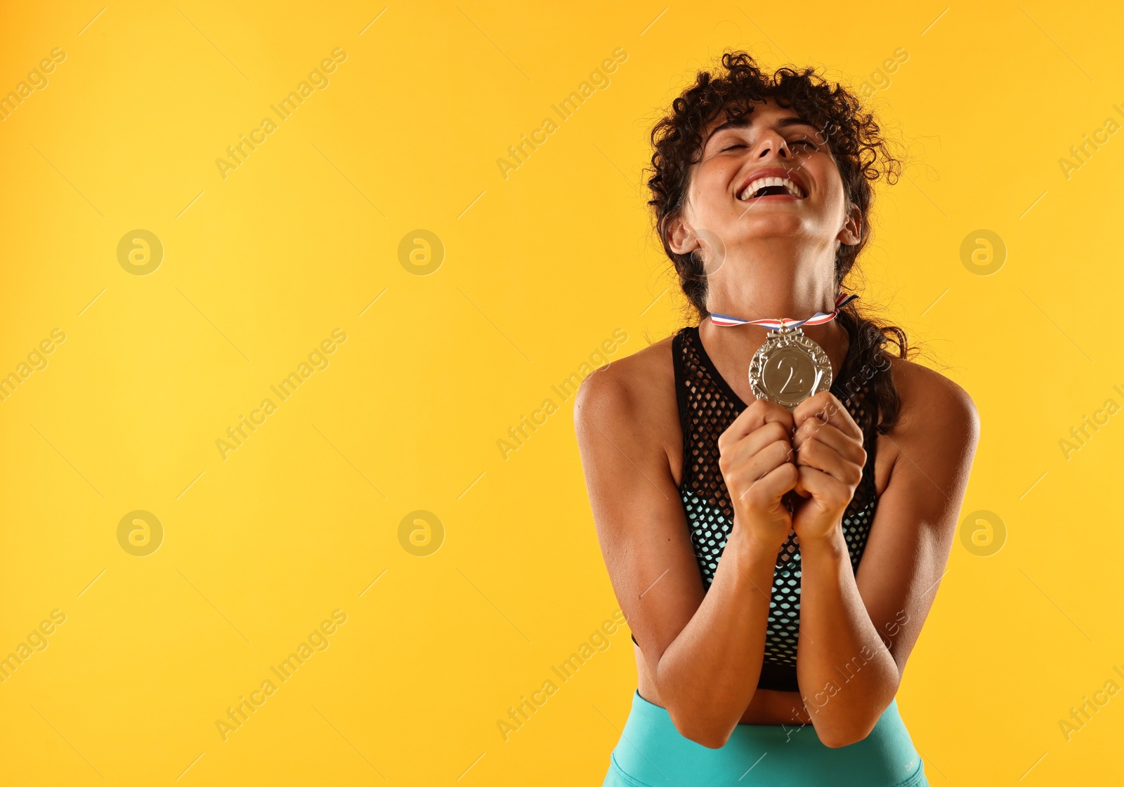 Photo of Happy winner with silver medal on yellow background. Space for text