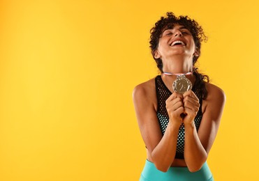 Photo of Happy winner with silver medal on yellow background. Space for text