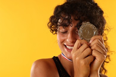 Photo of Happy winner with silver medal on yellow background, closeup. Space for text