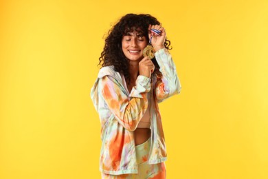 Photo of Happy winner with golden medal on yellow background