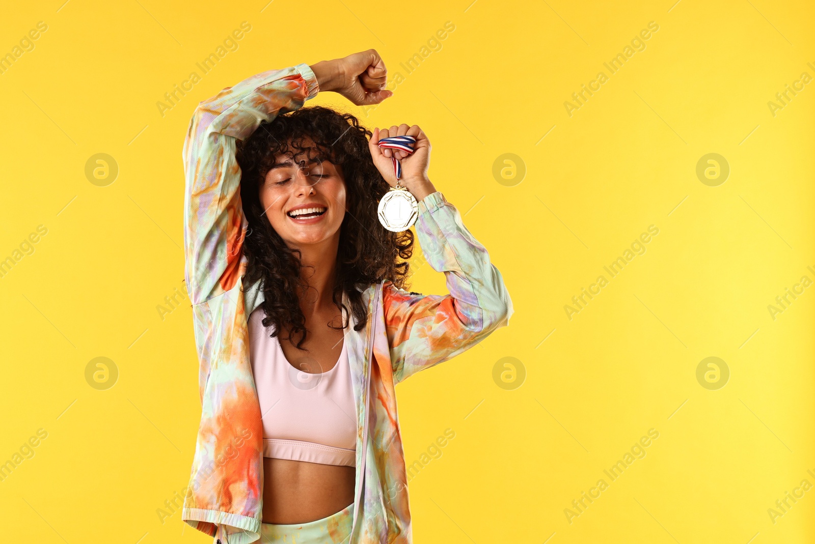 Photo of Happy winner with golden medal on yellow background. Space for text