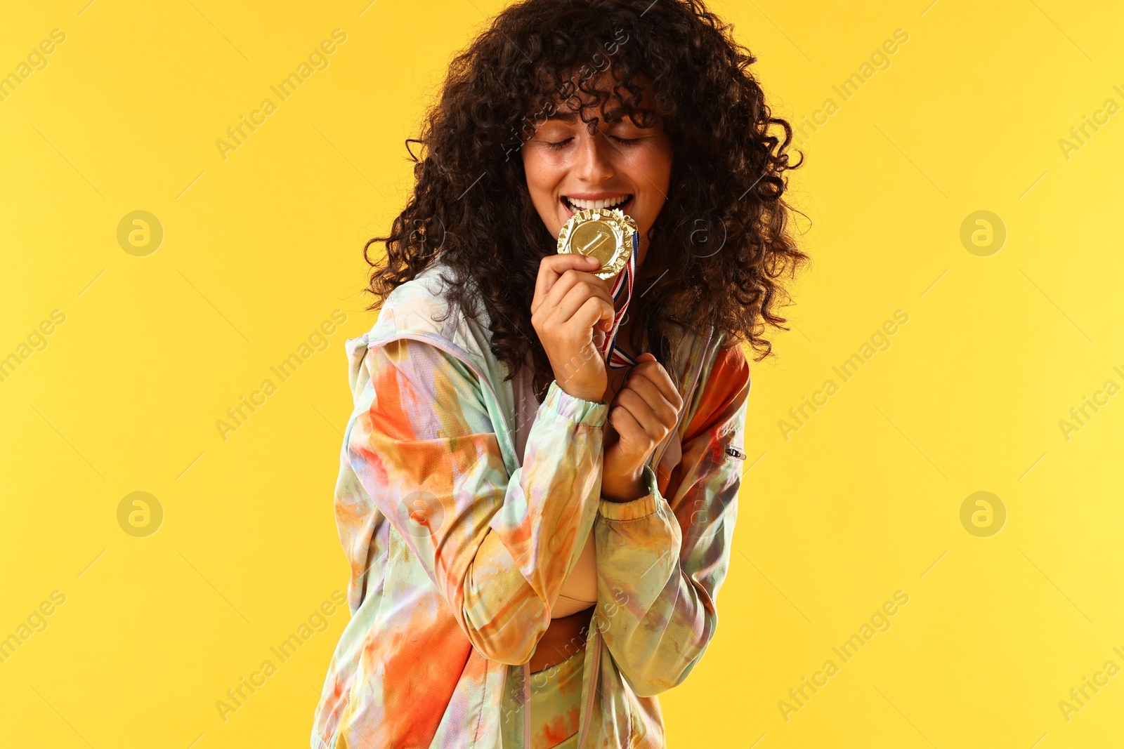 Photo of Happy winner with golden medal on yellow background