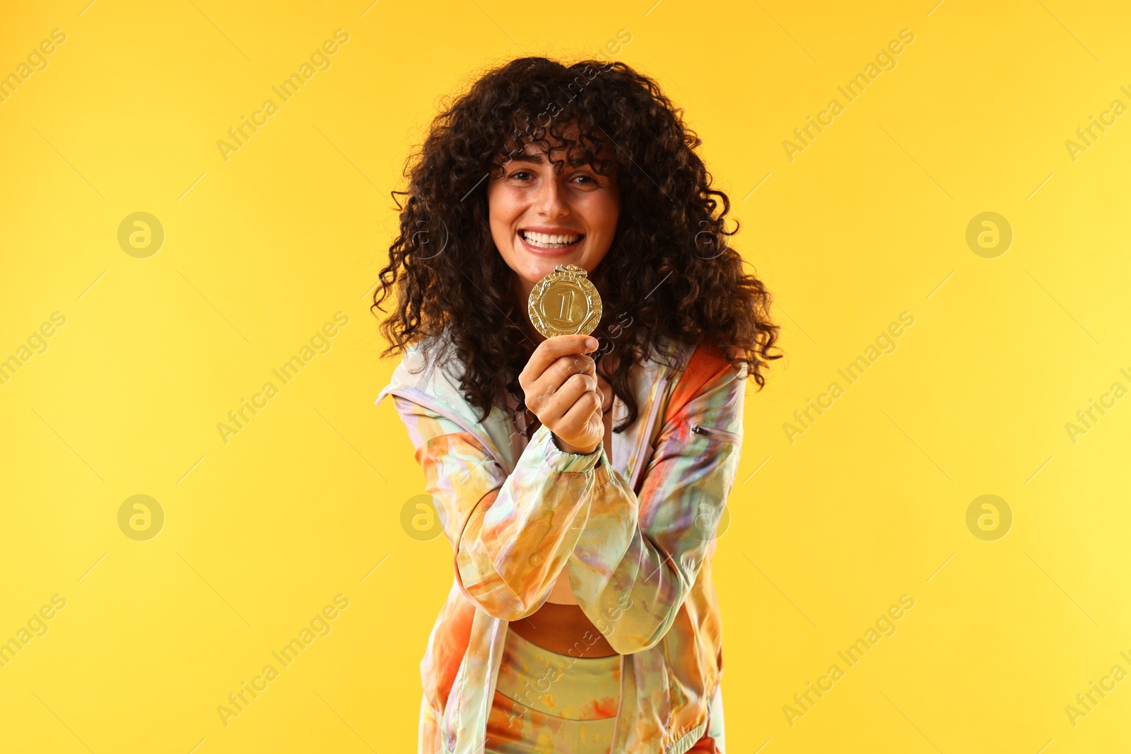 Photo of Happy winner with golden medal on yellow background