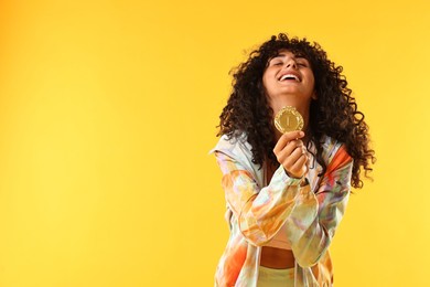 Photo of Happy winner with golden medal on yellow background. Space for text